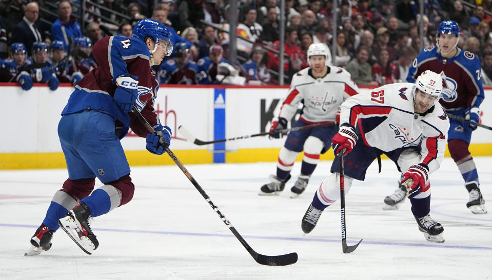 Colorado Avalanche defenseman Bowen Byram, left, looks to shoot the puck as Washington Capitals left wing Max Pacioretty defends in the second period of an NHL hockey game Wednesday, Jan. 24, 2024, in Denver. (AP Photo/David Zalubowski)
