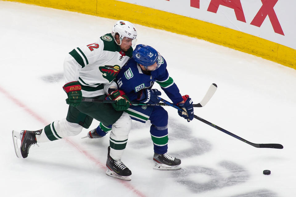 Vancouver Canucks' Elias Pettersson (40) is pursued by Minnesota Wild's Eric Staal (12) during the second period of an NHL hockey playoff game Sunday, Aug. 2, 2020, in Edmonton, Alberta. (Codie McLachlan/The Canadian Press via AP)