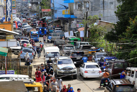 Residents who stayed at evacuation centers, due to the assault of government troops against pro-Islamic State militant groups, walk after they were allowed to return to their homes in Basak, Malutlut district in Marawi city, southern Philippines October 29, 2017. REUTERS/Romeo Ranoco