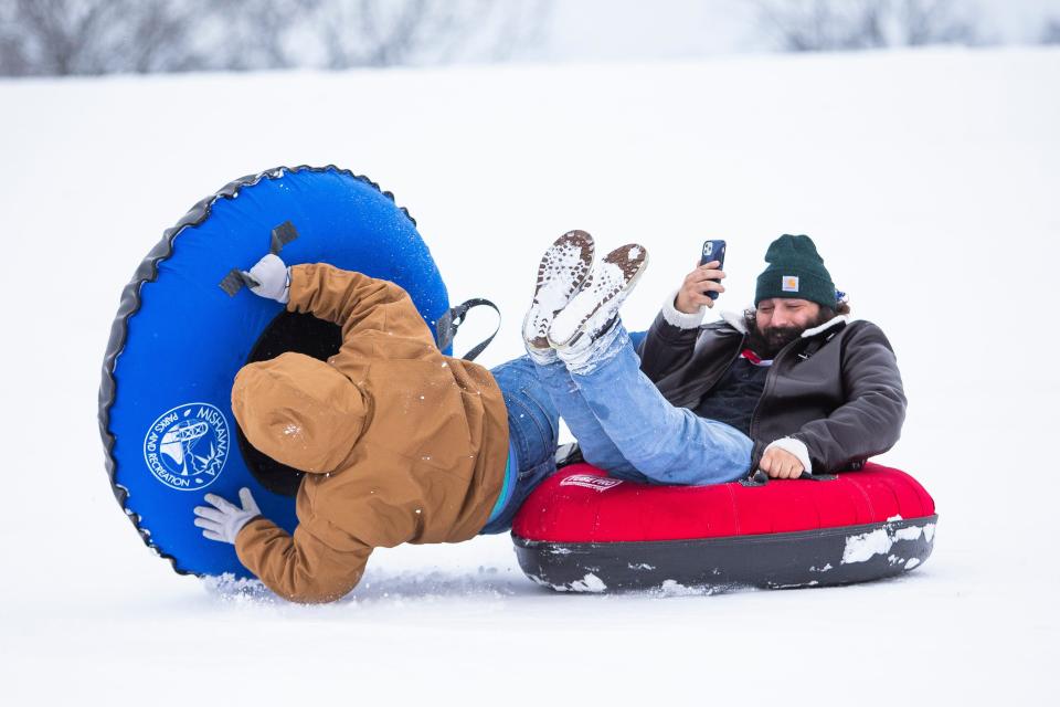 Rhiannon Gard collides with Zach Burnes while he takes a video Monday, Jan. 24, 2022 at George Wilson Park in Mishawaka.  