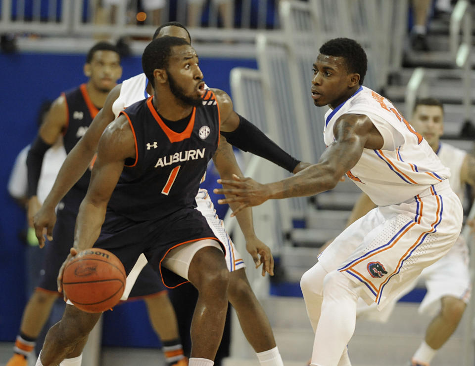 Auburn guard KT Harrell (1) tries to get past Florida forward Casey Prather (24) during the first half of an NCAA college basketball game Wednesday Feb. 19, 2014 in Gainesville, Fla. (AP Photo/Phil Sandlin)