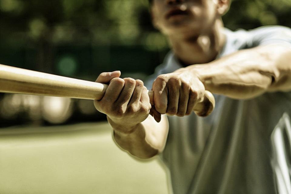 man practicing baseball bat swing