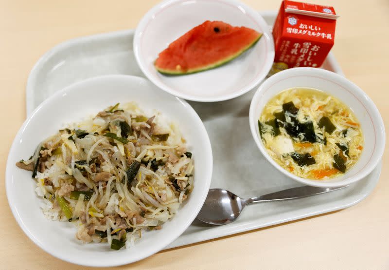 A school lunch meal including onion salt pork bowl, soup, packet of milk and sliced watermelon is seen at Senju Aoba Junior High School in Tokyo