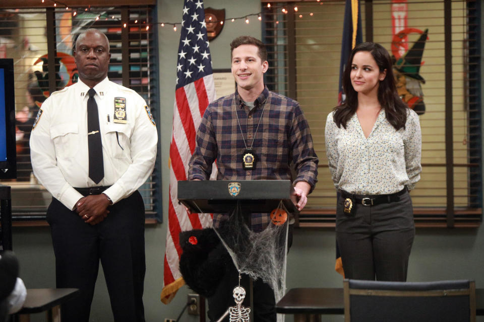 Andre Braugher, Andy Samberg, and Melissa Fumero deliver a speach at the front of the precinct
