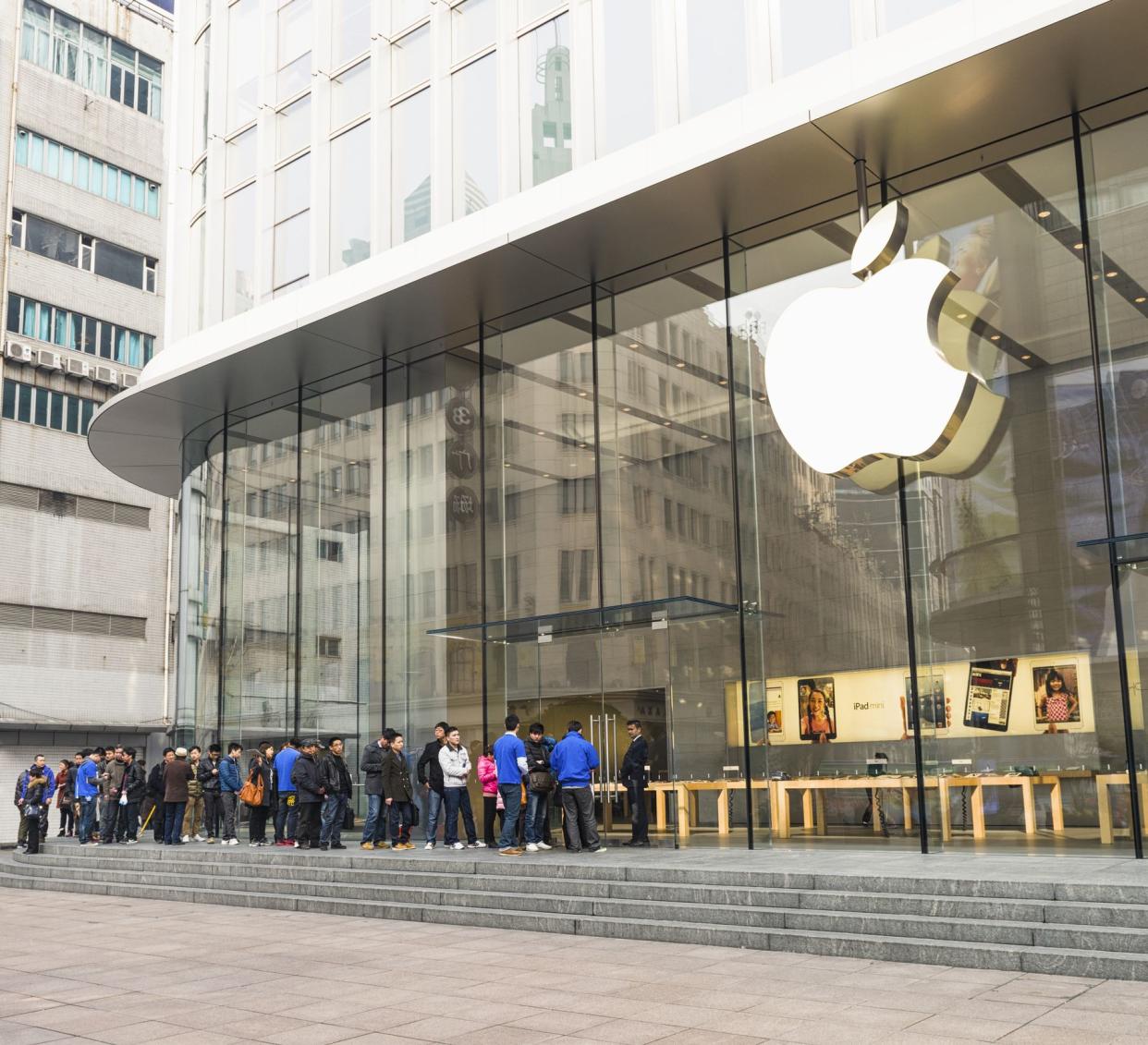 Shanghai, China - March 5, 2013: Customers waiting in a queue outside the Apple Store on East Nanjing Road in central Shanghai.