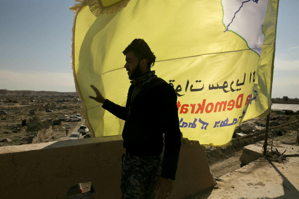 A U.S.-backed Syrian Democratic Forces (SDF) fighter stands on a rooftop overlooking Baghouz, Syria, after the SDF declared the area free of Islamic State militants after months of fighting on Saturday, March 23, 2019. The elimination of the last Islamic State stronghold in Baghouz brings to a close a grueling final battle that stretched across several weeks and saw thousands of people flee the territory and surrender in desperation, and hundreds killed. (AP Photo/Maya Alleruzzo)