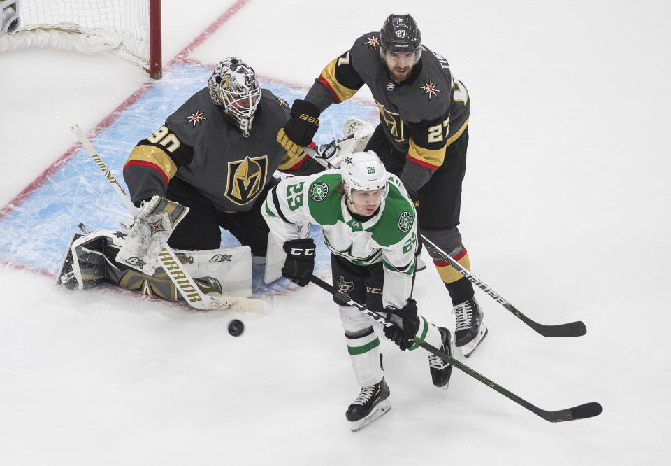 Dallas Stars' Joel Kiviranta (25) and Vegas Golden Knights' Shea Theodore (27) look for a rebound from Golden Knights goalie Robin Lehner (90) during third-period NHL Western Conference final playoff game action in Edmonton, Alberta, Monday, Sept. 14, 2020. (Jason Franson/The Canadian Press via AP)