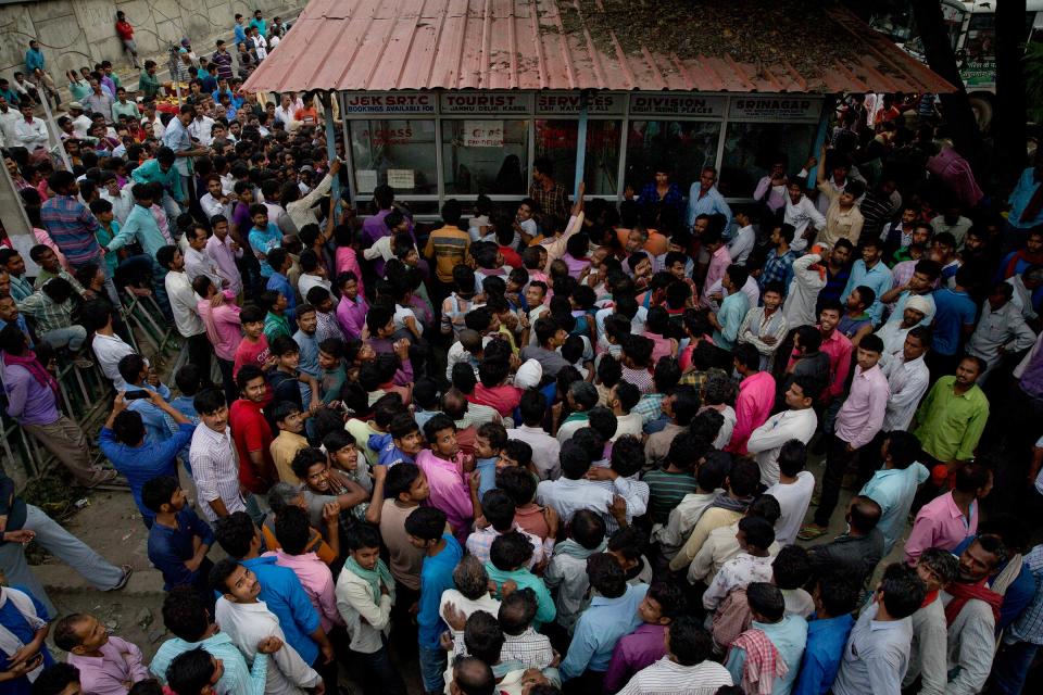 Indian migrant workers crowd outside the government transport yard to buy bus tickets to leave the region, during curfew in Srinagar, Indian controlled Kashmir, Wednesday, Aug. 7. | Dar Yasin—AP