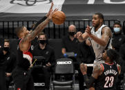 San Antonio Spurs center LaMarcus Aldridge, right , passes the ball against Portland Trail Blazers guard Damian Lillard, left, during the second half of an NBA basketball game in Portland, Ore., Monday, Jan. 18, 2021. (AP Photo/Steve Dykes)