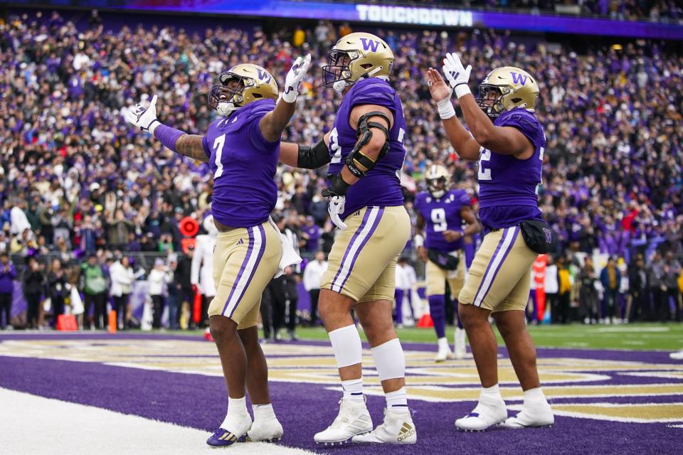 Washington running back Dillon Johnson (7) celebrates scoring a touchdown with offensive lineman Roger Rosengarten, center, against Utah during the first half of an NCAA college football game Saturday, Nov. 11, 2023, in Seattle. | Lindsey Wasson, Associated Press