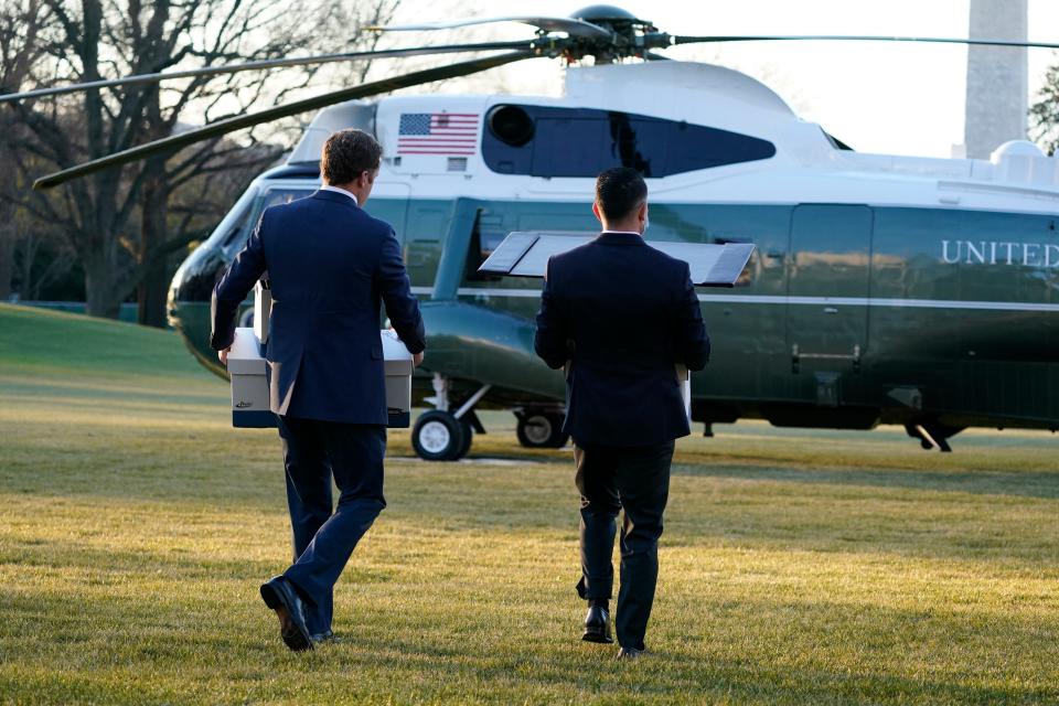 White House staff members carry boxes to Marine One before President Donald Trump leaves the White House on Jan. 20, 2021, en route to his Mar-a-Lago resort in Florida.