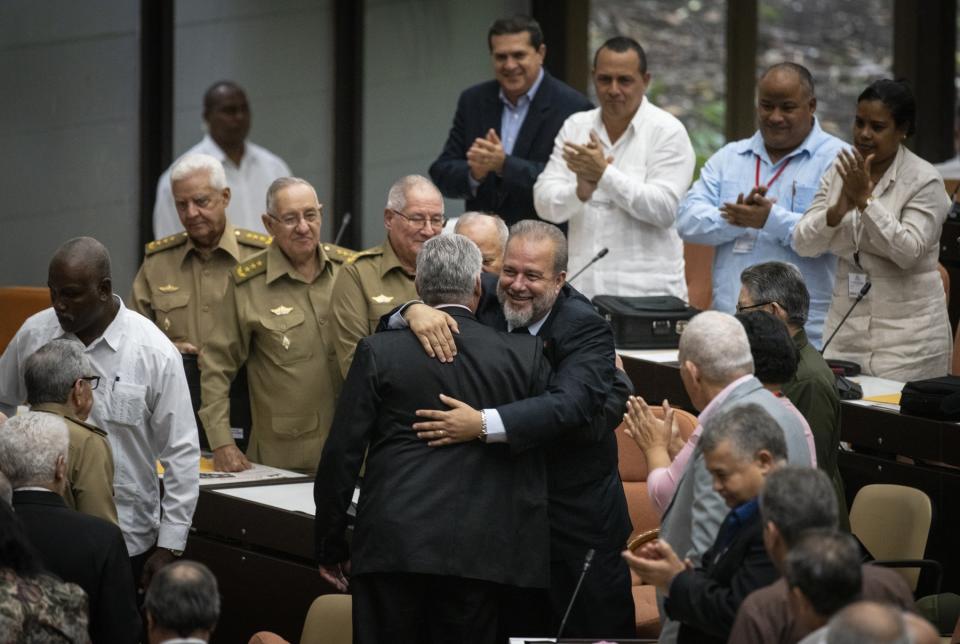 Cuban Prime Minister Manuel Marrero Cruz embraces Cuba's President Miguel Diaz-Canel during the closing session at the National Assembly of Popular Power in Havana, Cuba, Saturday, Dec. 21, 2019. Diaz-Canel named the former Tourism Marrero Cruz as the country's first prime minister since 1976. (AP Photo/Ramon Espinosa)