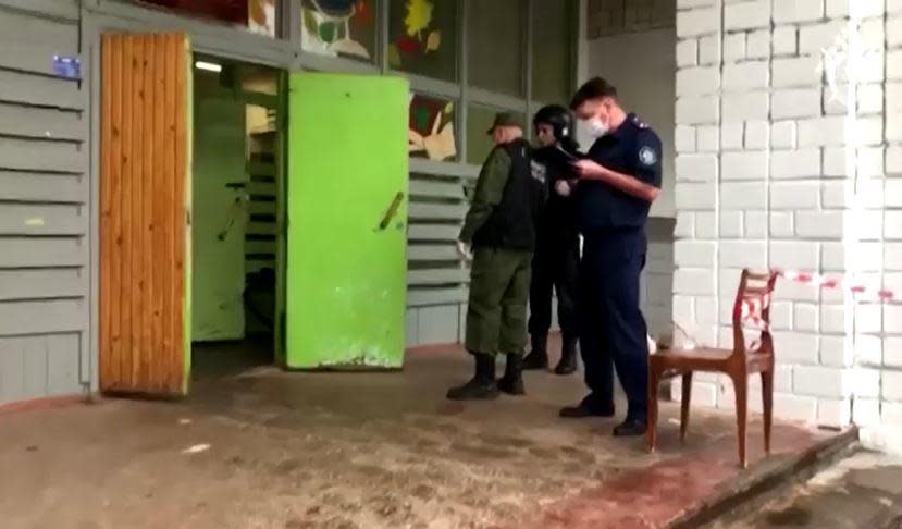  Law enforcement officers inspect an entrance to School No. 88, in the city of Izhevsk, Russia, about 600 miles east of Moscow, on September 26, 2022, after a gunman opened fire in the school, in an image provided by Russia's national Investigative Committee. / Credit: Russian national Investigative Committee