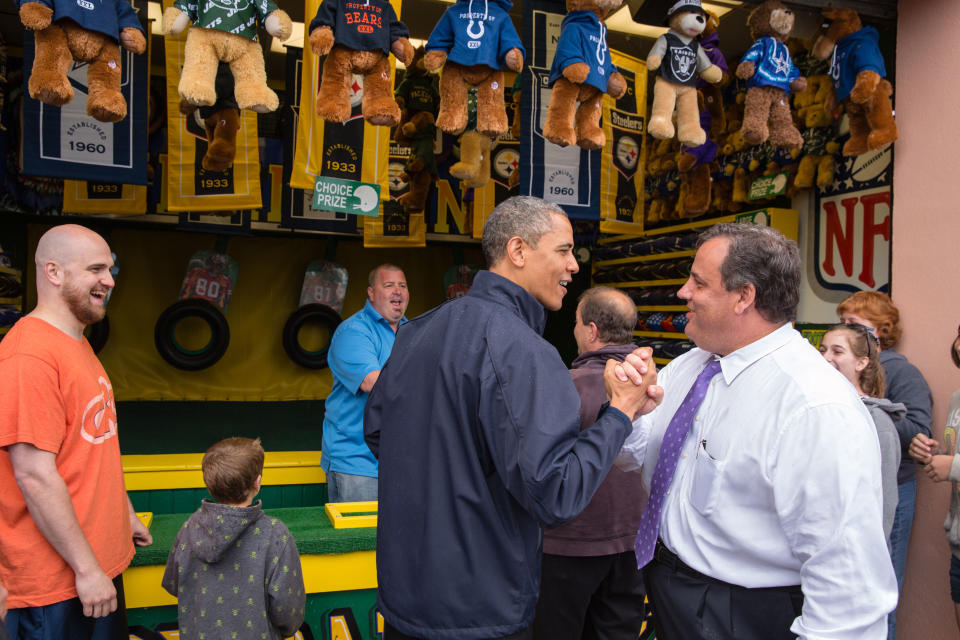 WASHINGTON, DC - MAY 28: In this handout provided by the White House, U.S. President Barack Obama (C) congratulates New Jersey Governor Chris Christie (R) while playing the "TouchDown Fever" arcade game along the Point Pleasant boardwalk May 28, 2013 in Point Pleasant Beach, New Jersey. Seven months after Superstorm Sandy devastated the region, President Obama declared that the Jersey Shore is back in an appearance with the governor. (Photo by Pete Souza/White House via Getty Images)