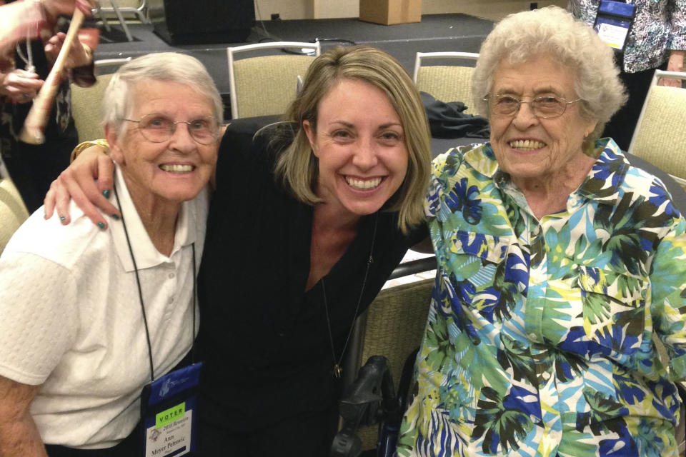 In this Sept. 8, 2018, photo provided by baseball illustrator Anika Orrock, Orrock, center, poses with former All-American Girls Professional Baseball League players Ann "Shorty" Meyer Petrovic, left, and Betsy "Sockum" Jochum, 99, at a league reunion in Kansas City, Mo. Orrock was all warmed up for her big pitch. On the mound at Yankee Stadium, tossing out the ceremonial first ball. On Tuesday night, May 5, 2020, though, the baseball illustrator and cartoonist will be far from the Bronx. Instead of starting off the Pirates-Yankees game, she’ll be back in Nashville, Tennessee, pondering her fate. No way to tour the country, promoting and celebrating the publication of her first book, based on the women pros popularized by the movie “A League of Their Own.” (Anika Orrock via AP)