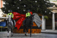 Two police officers ride their horses backdropped by a Christmas tree in Covent Garden, in London, Tuesday, Nov. 24, 2020. Haircuts, shopping trips and visits to the pub will be back on the agenda for millions of people when a four-week lockdown in England comes to an end next week, British Prime Minister Boris Johnson said Monday. (AP Photo/Alberto Pezzali)