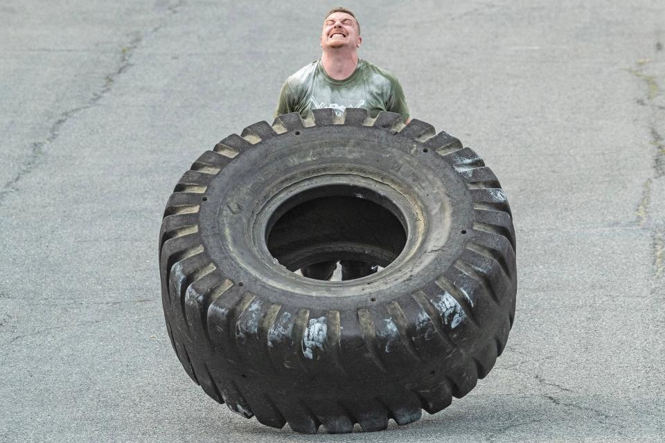 Bradie Crandall flips a 1,000-pound tire at the Training Center near New Castle on Thursday, Aug. 3, 2023. Crandall, a chemical engineering doctoral candidate at the University of Delaware, is among the nation's top powerlifters and a vegan.