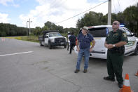 A Sarasota County Sheriff's Office deputy and a Sarasota County worker stand at the entrance to the Carlton Reserve during a search for Brian Laundrie, Tuesday, Sept. 21, 2021, in Venice, Fla. Laundrie is a person of interest in the disappearance of his girlfriend, Gabrielle "Gabby" Petito. (AP Photo/Phelan M. Ebenhack)