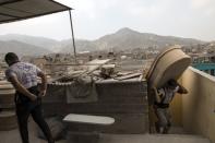 Wilfredo Cabrera carries a new coffin to a store inside a coffin factory in the Juan de Lurigancho neighborhood of Lima, Peru, Thursday, June 4, 2020. As the number of COVID-19 deaths in Peru rapidly mounts, the South American country is becoming one of the epicenters for the virus outbreak in Latin America. (AP Photo/Rodrigo Abd)