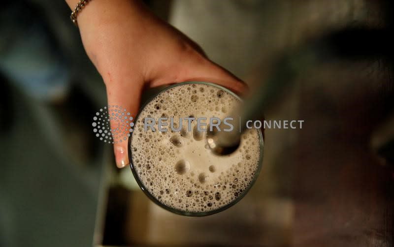 FILE PHOTO: A bartender pulls a pint of bitter at the Flying Horse pub in London