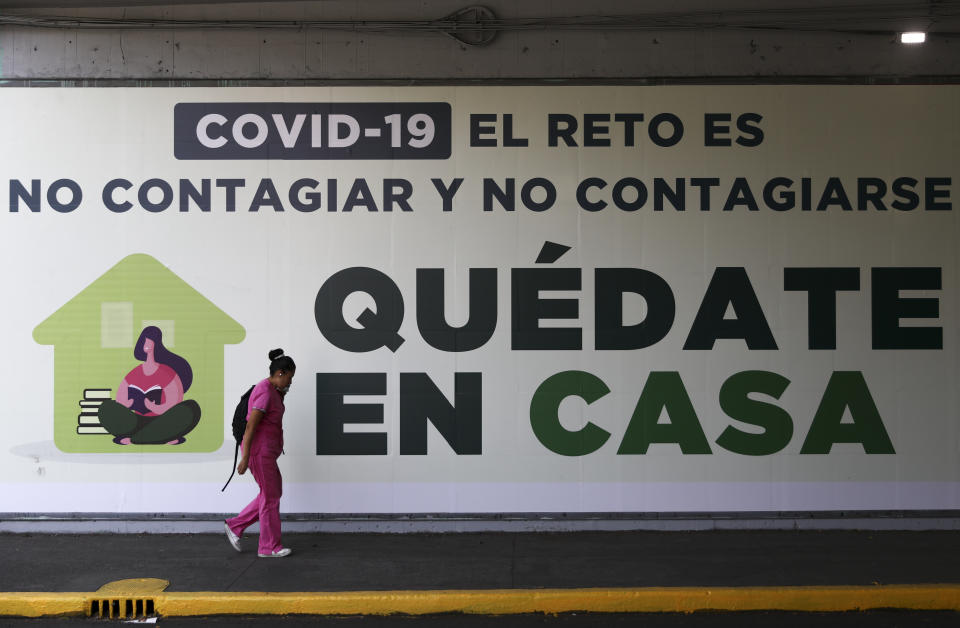 Una mujer pasa enfrente de un letrero sobre el coronavirus en Ciudad de México, el martes 31 de marzo de 2020. (AP Foto / Eduardo Verdugo)