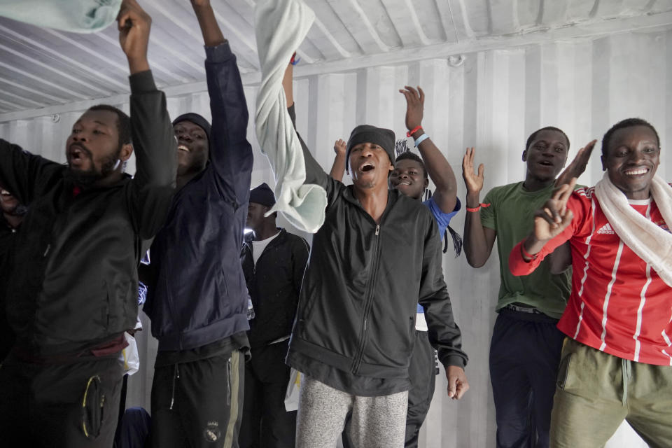 Migrants celebrate after receiving news of their assigned place of safety, aboard the Ocean Viking in the Mediterranean Sea, Monday, Sept. 23, 2019. Italy has granted the humanitarian ship permission to sail to the port of Messina in Italy to disembark 182 people rescued north of Libya. (AP Photo/Renata Brito)