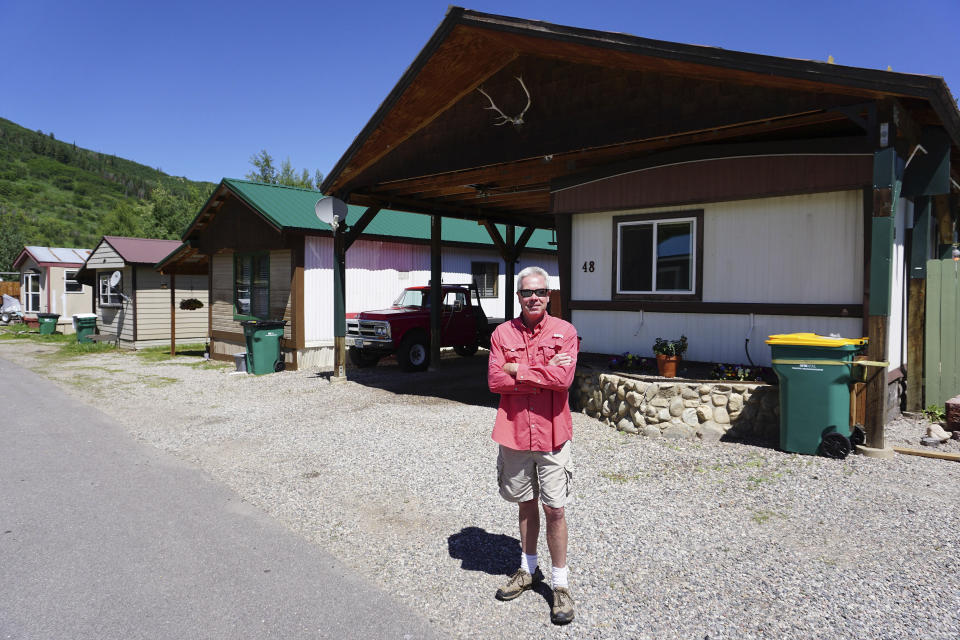 In this July 6, 2019, photo Jeff Morehead stands near his home at the Fish Creek Mobile Home Park in Steamboat Springs, Colo. Some Colorado towns are taking action to preserve their remaining mobile home parks. Cities, counties and housing authorities, such as the Yampa Valley Housing Authority in Steamboat Springs, are buying mobile home parks to preserve affordable housing for residents as other mom-and-pop park owners sell out to developers or investors.(Matt Stensland/The Colorado Sun via AP)