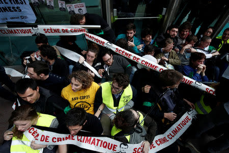 Environmental activists block the entrance of the French bank Societe Generale headquarters during a "civil disobedience action" to urge world leaders to act against climate change, in La Defense near Paris, France, April 19, 2019. REUTERS/Benoit Tessier