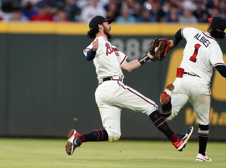 Atlanta Braves shortstop Dansby Swanson collides with second baseman Ozzie Albies as he catches a fly ball from New York Mets' Jonathan Villar during the fifth inning of a baseball game Tuesday, May 18, 2021, in Atlanta. (AP Photo/John Bazemore)