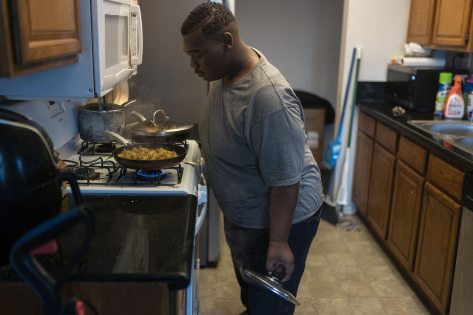 John Simon, a teenager who had a bariatric surgery in 2022, cooks dinner for his family in Los Angeles, Monday, March 13, 2023. (AP Photo/Jae C. Hong)