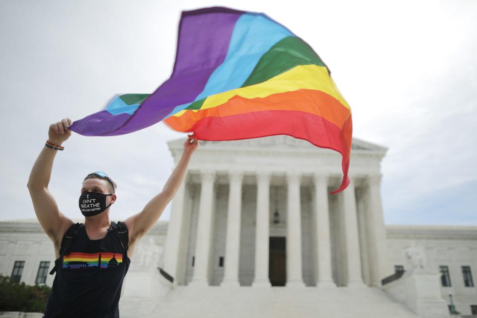 Joseph Fons holds a Pride Flag in front of the U.S. Supreme Court building after the court ruled that LGBTQ people can not be disciplined or fired based on their sexual orientation June 15, 2020 in Washington, DC.