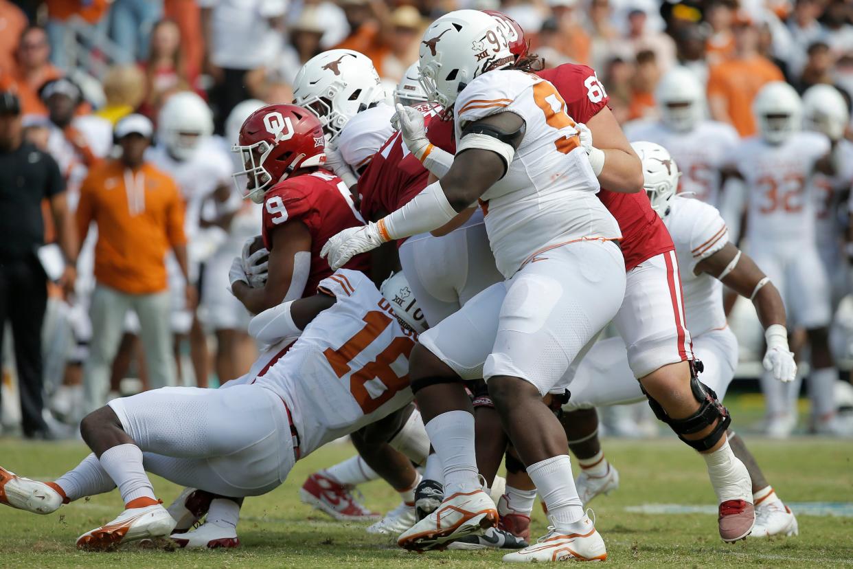 Texas defenders take down Oklahoma tight end Brayden Willis during last year's 49-0 Longhorns win at their annual Red River Showdown game at the Cotton Bowl. Both the Longhorns and Sooners will leave the Big 12 next July to join the SEC.