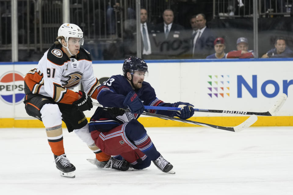 New York Rangers' Alexis Lafreniere, right, slips as he is pursued by Anaheim Ducks' Leo Carlsson during the second period of an NHL hockey game Friday, Dec. 15, 2023, in New York. (AP Photo/Seth Wenig)