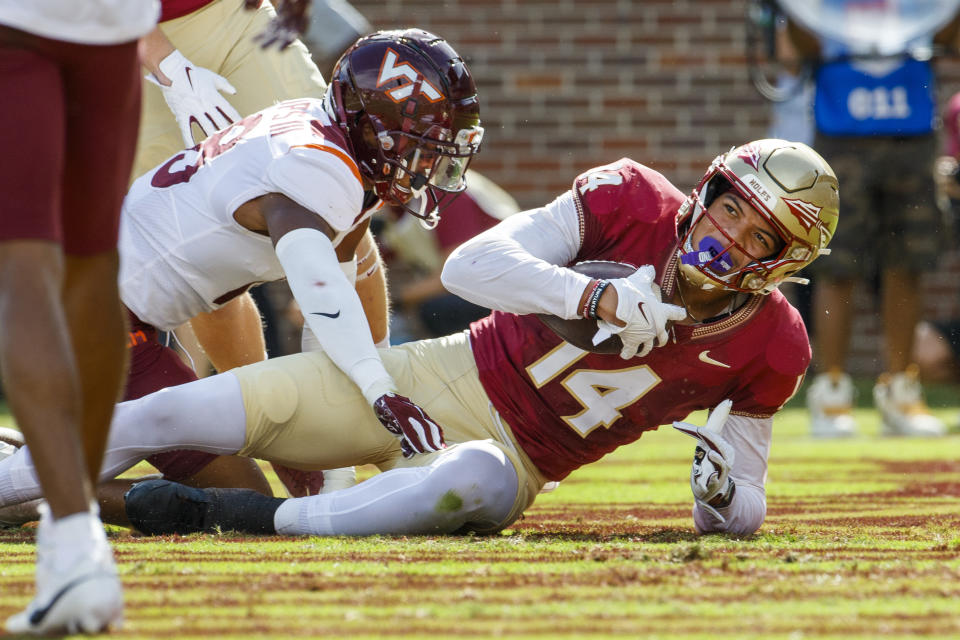 Florida State wide receiver Johnny Wilson (14) right, gets by Virginia Tech safety Mose Phillips III (18) for Florida State's first touchdown during the first half of an NCAA college football game, Saturday, Oct. 7, 2023, in Tallahassee, Fla. (AP Photo/Colin Hackley)