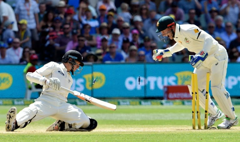 New Zealand batsman Mitchell Santner (L) is stumped out by Australian wicketkeeper Peter Nevill off spin bowler Nathan Lyon during the third day of the day-night Test at the Adelaide Oval on November 29, 2015