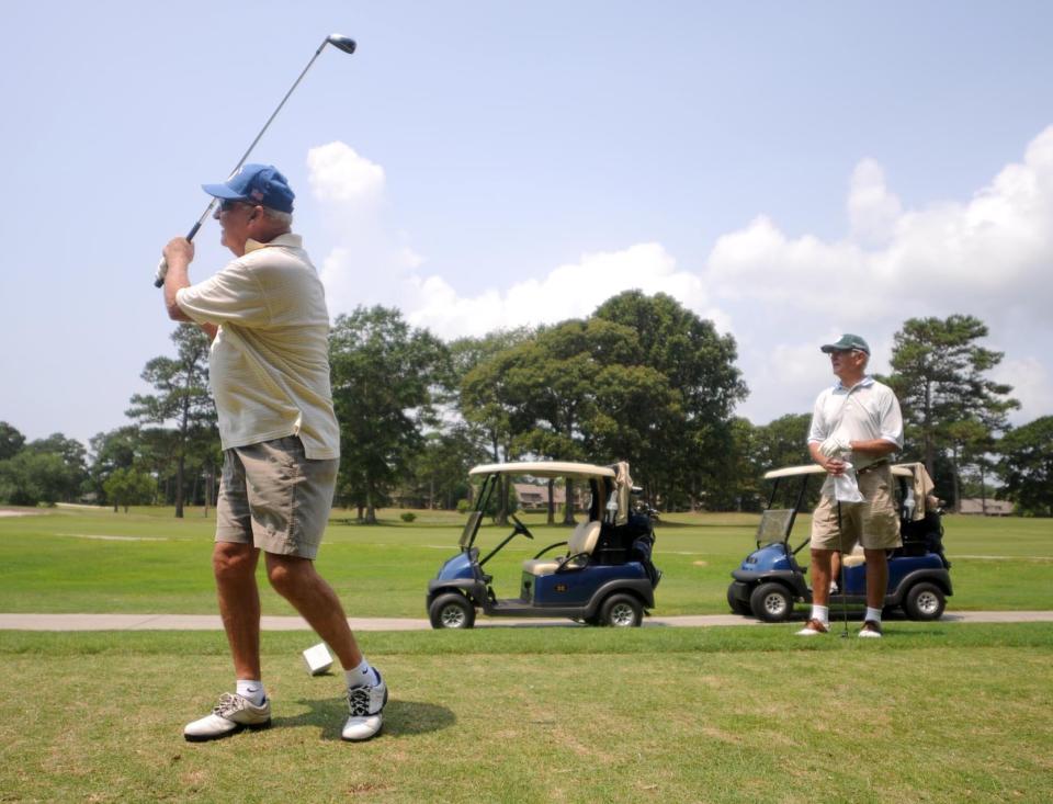 Ted Kincaid, left, and Rodger Wyland tee off on the second hole at Olde Point Country Club in Hampstead.  [FILE PHOTO/STARNEWS]