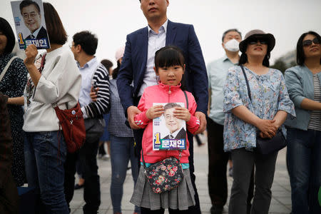 A girl holds a portrait of Moon Jae-in, the presidential candidate of the Democratic Party of Korea, before his election campaign rally in Goyang, South Korea, May 4, 2017. REUTERS/Kim Hong-Ji