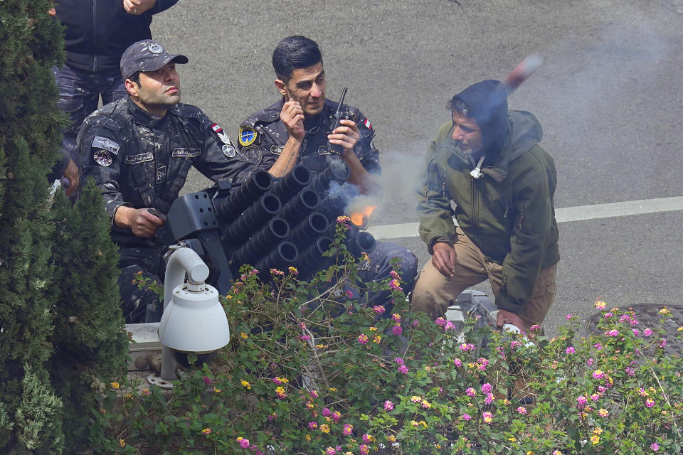 Lebanese soldiers from the Government Guard unit, fire tear gas against retired army soldiers and other protesters who are protesting demanding better pay, in Beirut, Lebanon, Wednesday, March 22, 2023. Lebanese security forces fired tear gas to disperse hundreds of protesters who tried to break through the fence leading to the government headquarters in downtown Beirut Wednesday amid widespread anger over the harsh economic conditions in the country. (AP Photo/Bilal Hussein)