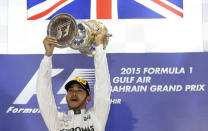 Mercedes Formula One driver Lewis Hamilton of Britain celebrates his victory on the podium with the winner's trophy after Bahrain's F1 Grand Prix at Bahrain International Circuit, south of Manama April 19, 2015. REUTERS/Ahmed Jadallah