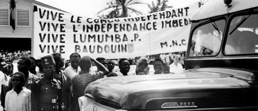 Photo publiée le 18 décembre 1960 à Stanleyville (aujourd'hui Kisangani) de Congolais tenant une banderole revendiquant l'indépendance du Congo et soutenant le dirigeant Patrice Lumumba, alors que le roi Baudouin de Belgique visite l'ancienne colonie du Congo belge (Congo Belge), aujourd'hui appelée République démocratique du Congo (RDC). Le Congo belge est devenu indépendant le 30 juin 1960.   - Credit:AFP