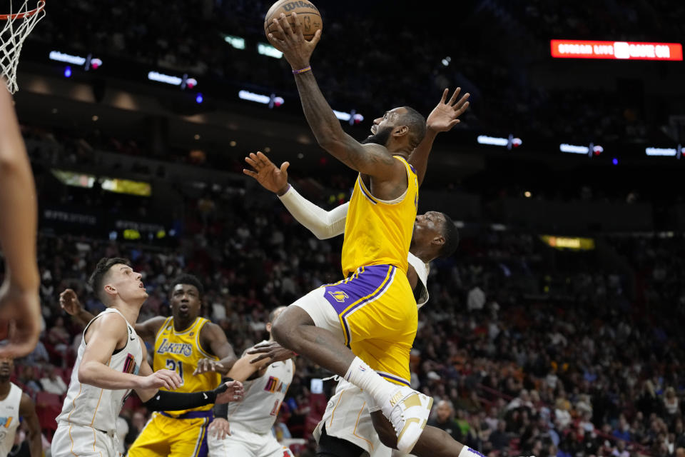 Los Angeles Lakers forward LeBron James goes to the basket as Miami Heat center Bam Adebayo, right, defends during the second half of an NBA basketball game, Wednesday, Dec. 28, 2022, in Miami. The Heat won 112-98. (AP Photo/Lynne Sladky)