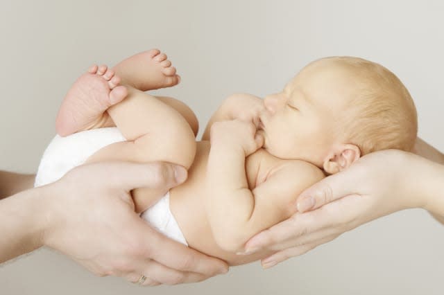 baby newborn sleeping on parents hands, kid and family concept