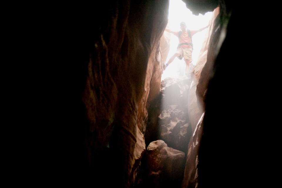 A man climbs through a canyon