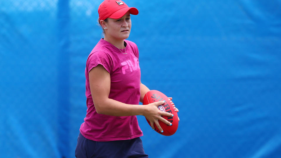 Ashleigh Barty, pictured here warming up with an AFL ball before a tennis match.