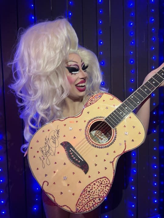 Drag performer Brigitte Bandit holds the sparkly guitar sent to her and signed by Dolly Parton. (Courtesy: Brigitte Bandit)