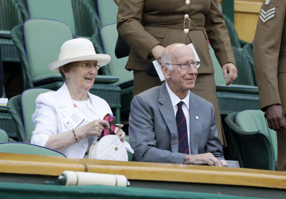 FILE - Former England soccer player Bobby Charlton and his wife sit in the Royal Box on Centre Court on the sixth day of the Wimbledon Tennis Championships in London, July 7, 2018. Bobby Charlton, an English soccer icon who survived a plane crash that decimated a Manchester United team destined for greatness to become the heartbeat of his country's 1966 World Cup-winning team, has died. He was 86. A statement from Charlton's family, released by United, said he died Saturday Oct. 21, 2023 surrounded by his family. (AP Photo/Kirsty Wigglesworth, File)