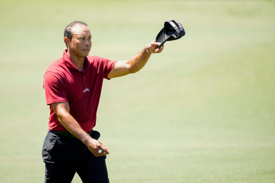 Tiger Woods tips his hat to patrons as he walks up No. 18 during the final round of the Masters.
