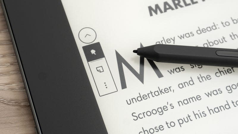 A close-up of the Kindle Scribe's on-screen sticky note menu for ebooks, with the device sitting on a wooden table.