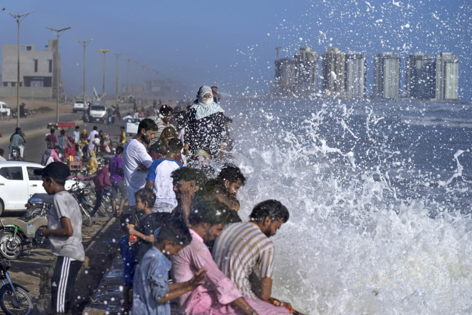 People enjoy high tide waves on the Arabian Sea, in Karachi, Pakistan, Sunday, June 11, 2023. Pakistani Prime Minister Shehbaz Sharif ordered officials to put in place emergency measures in advance of the approaching Cyclone Biparjoy in the Arabian Sea. The "severe and intense" cyclone with wind speeds of 150 kilometers per hour (93 miles per hour) was on a course toward the country's south, Pakistan's disaster management agency said. (AP Photo/Fareed Khan)