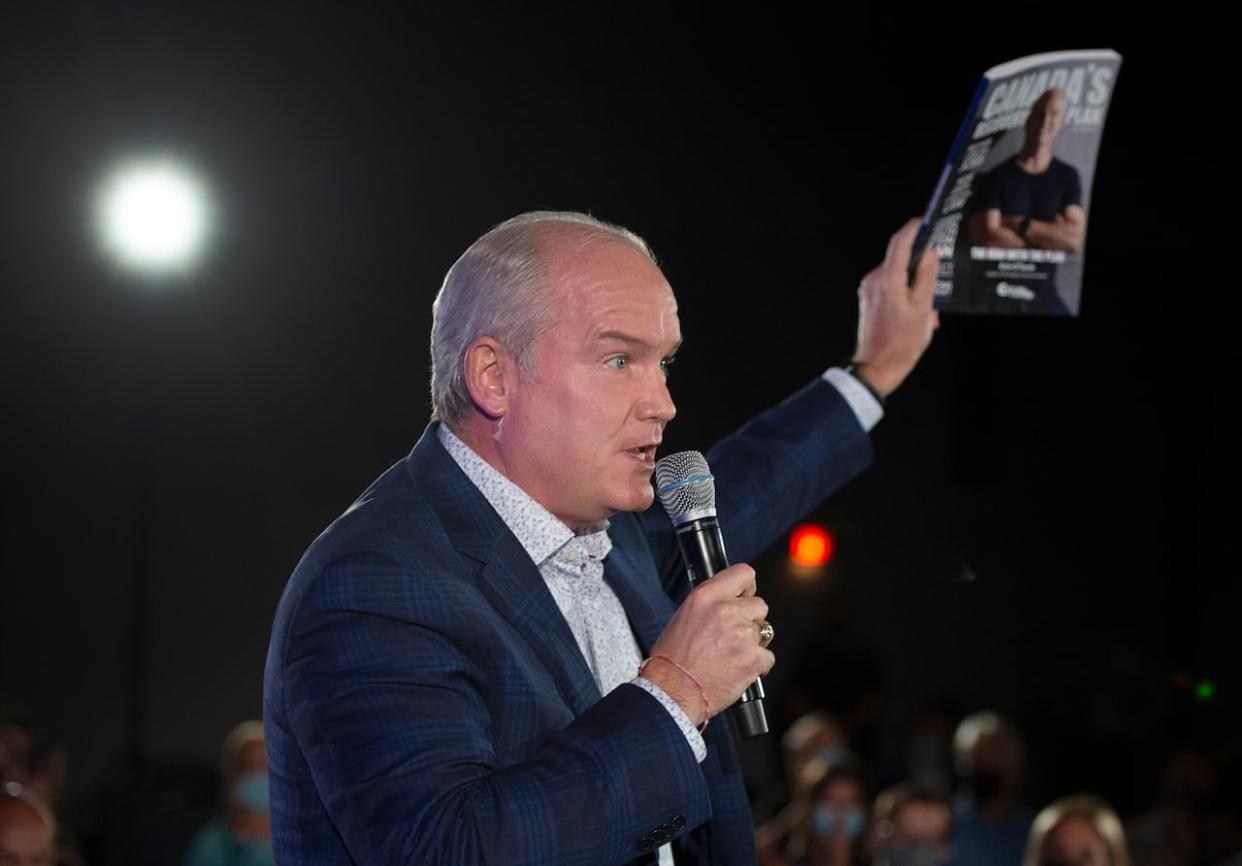 Then-Conservative leader Erin O'Toole holds up his platform book as he speaks to supporters at a campaign rally on Wednesday, August 25, 2021 in Hamilton, Ont. (Ryan Remiorz/Canadian Press - image credit)